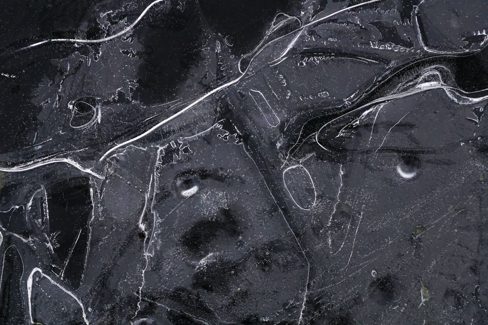 Fragment of thin ice on dark frozen river
