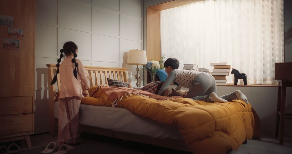 Happy Korean Family in the Morning: Active and Playful Children Running to Their Parents' Bedroom to Wake Them Up.