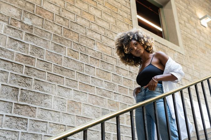 Black woman standing near railing of stairway