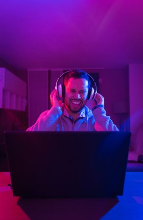 Man listening cheerfully to music with headphones.