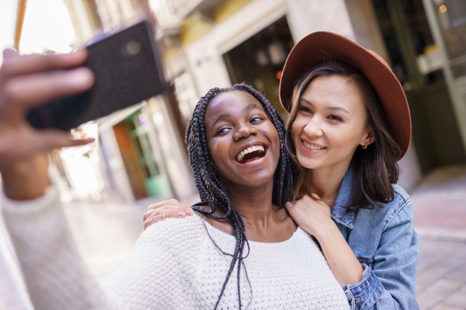 Female friends smiling at camera phone for a selfie