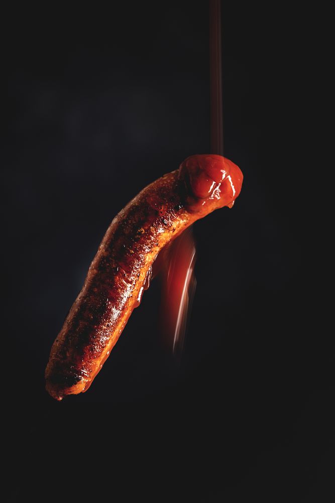 ketchup falling on grilled sausage