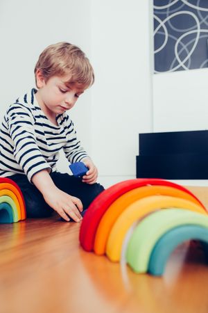 Boy playing with wooden construction pieces