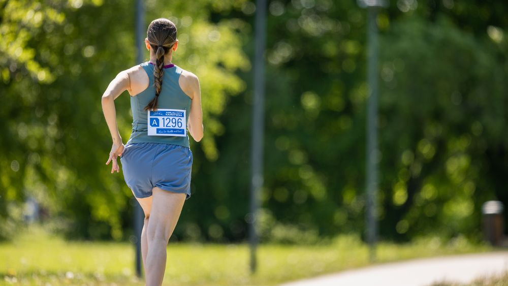 Portrait of a Young Athletic Female Jogger Running in a Park on a Health Trail.