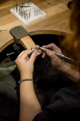 unrecognizable woman grinding ring in jewelry atelier