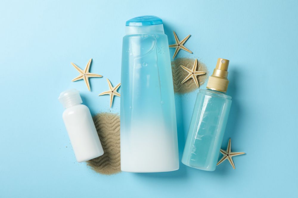 Composition of personal hygiene with bottles of cosmetics on blue background