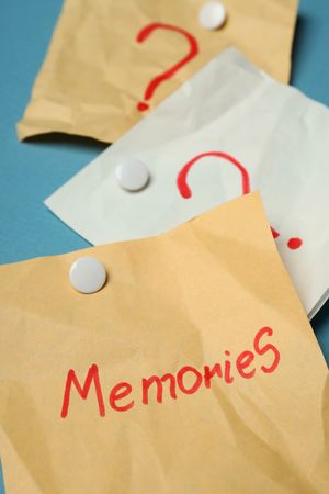 Pinned post it notes with the word “memories” on blue board, vertical