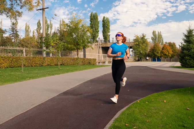 Female runner in blue shirt jogs along scenic path