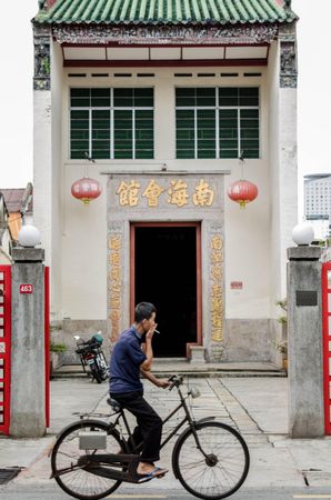 man riding a bike on the road in George Town, Penang, Malaysia