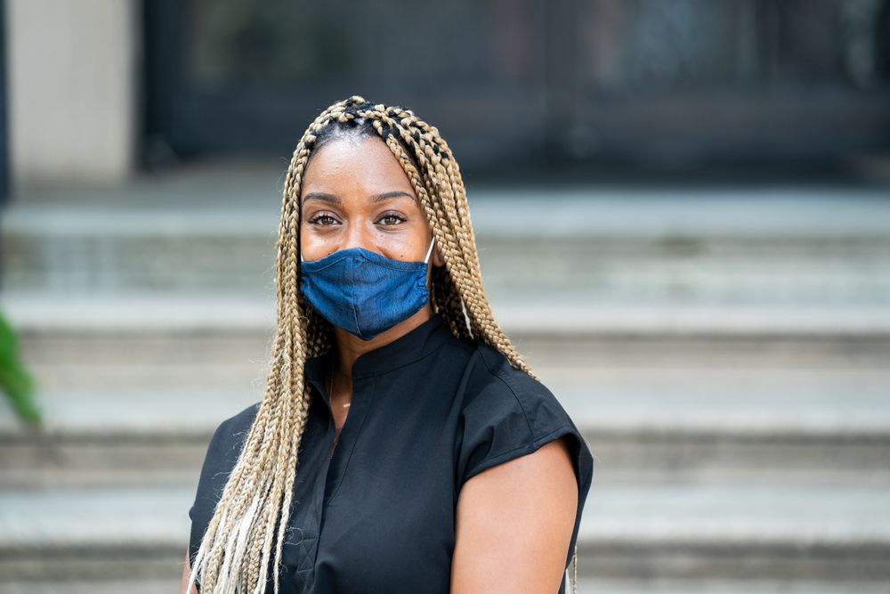 Portrait of medical worker in mask and black scrubs looking at camera