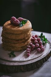 Pile of raspberry pancakes with honey on plate