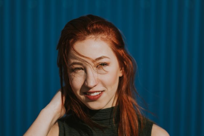 Smiling woman squinting in sun and enjoying weather