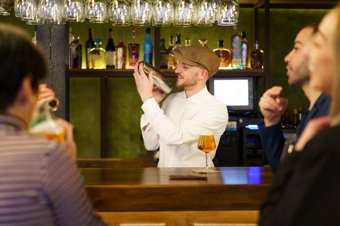Bartender shaking cocktail behind bar