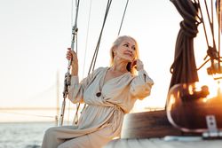 Stylish mature woman leaning back on a yacht bow