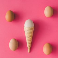 Ice cream cone with egg on pink background