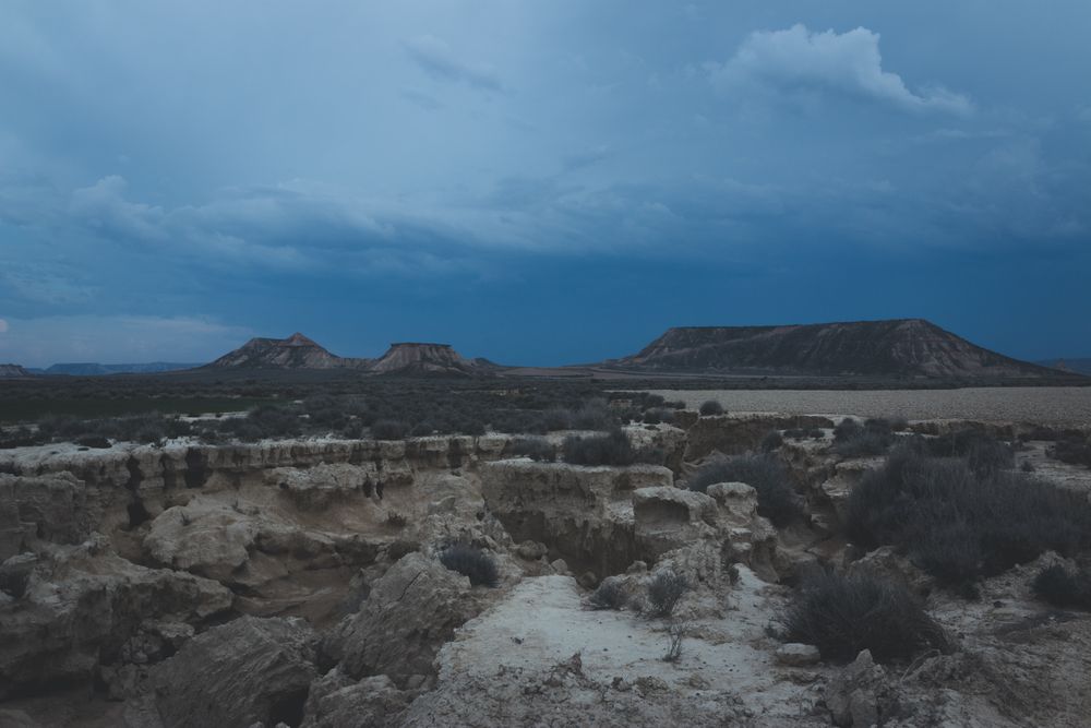 Man standing on stone in desert hills