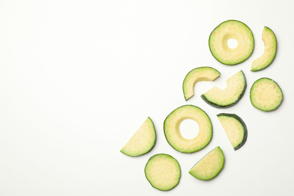 Flat lay with avocado slices on plain background, top view