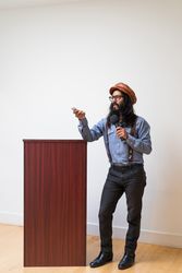 Man holding a remote and microphone giving a presentation