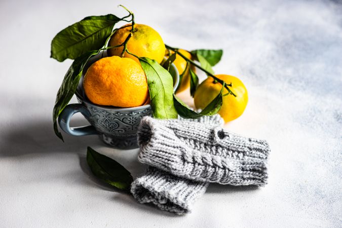 Organic tangerines in cup with woolen cosy