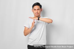 Asian male in grey studio making “time out” gesture 5qaz15