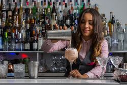 Bartender pouring a shaken cocktail to a glass