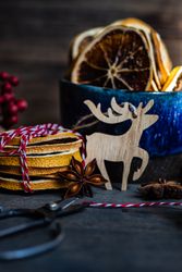 Side view of slices of dried orange in blue mug on Christmassy table