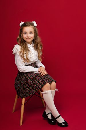 Full-length portrait preteen schoolgirl on vivid red colored background