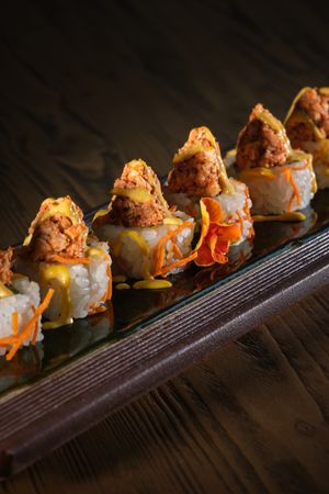 Appetizing sushi topped with salmon and fresh sauce