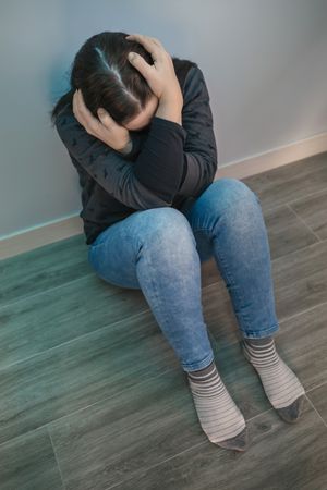 Unrecognizable woman holding head in anguish