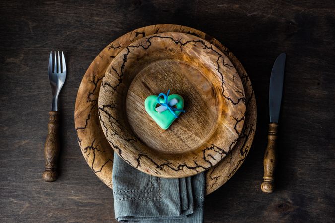 Valentine's day card concept of teal heart decoration on rustic plate