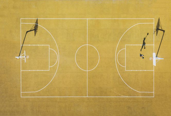 Young man playing basketball on outdoor court.