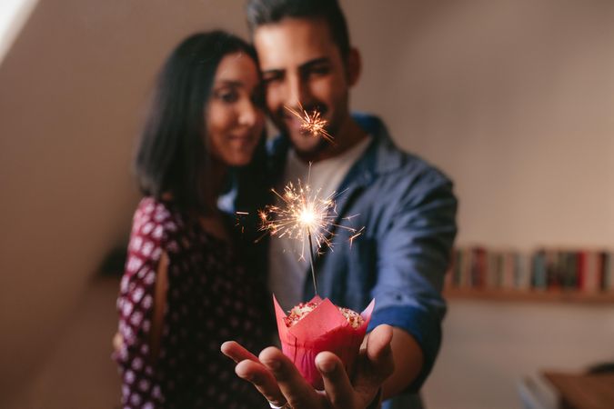 Loving couple celebrating anniversary with sparkler firework