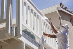 House Painter Spray Painting A Deck of A Home