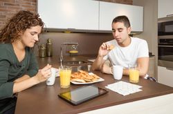 Couple eating pastries and drinking coffee at breakfast