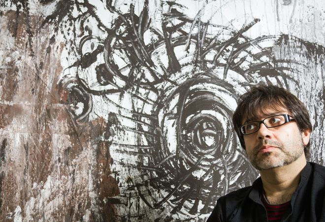 Painter artist posing in front of paint