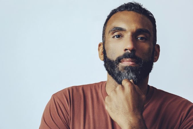 Head shot of thinking Black male in grey studio