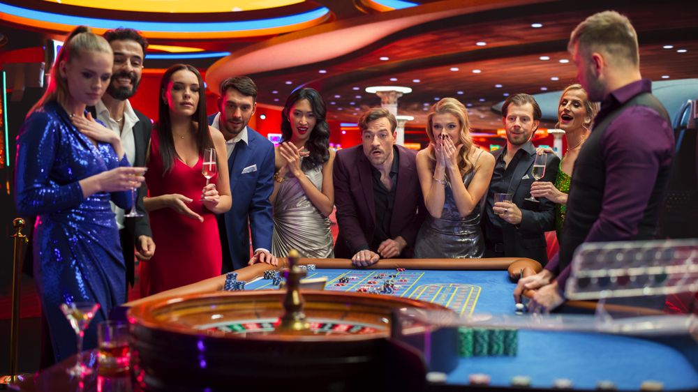 Casino Players Making Bets at a Roulette Table. Vibrant Crowd of International Young People Enjoying Nightlife in a City.