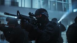 Masked Squad of Armed SWAT Police Officers Stand in Dark Seized Office Building with Desks and Computers.