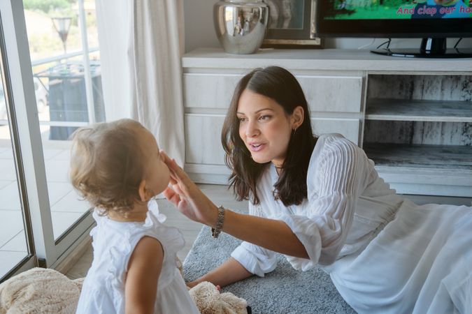 Mother playing with daughter at home
