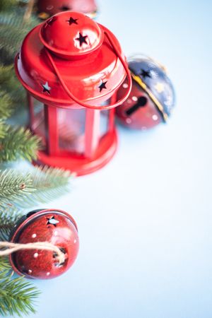 Christmas red lantern, bell and branch on blue background