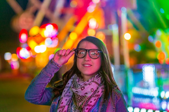 Stylish young woman near illumination on street
