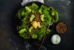 Top view of green fresh salad on concrete background with copy space