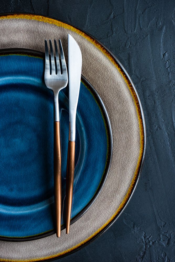 Rustic table setting with cutlery on ceramic navy plate