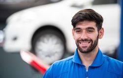 Smiling male mechanic at auto shop