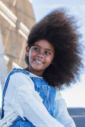 Smiling Black teen girl with curly hair