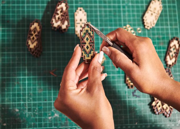 Close up of hands assembling earrings with pliers