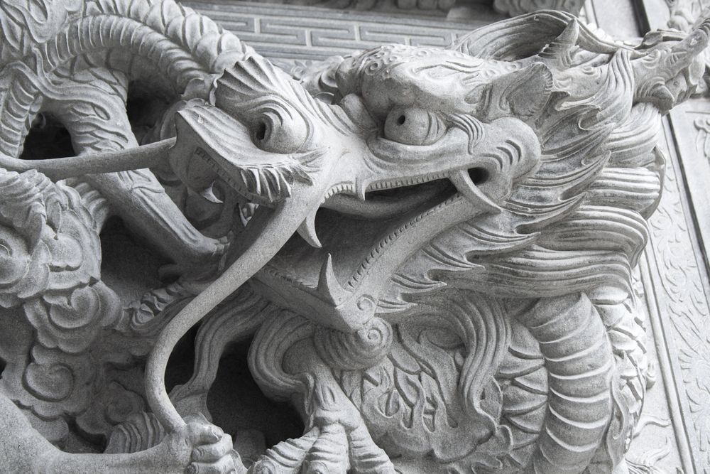 A wall with dragon stone sculpture in chineese temple.