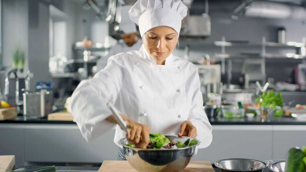 In a Famous Restaurant Female Cook Prepares Salad. She Works in a Big Modern Kitchen.