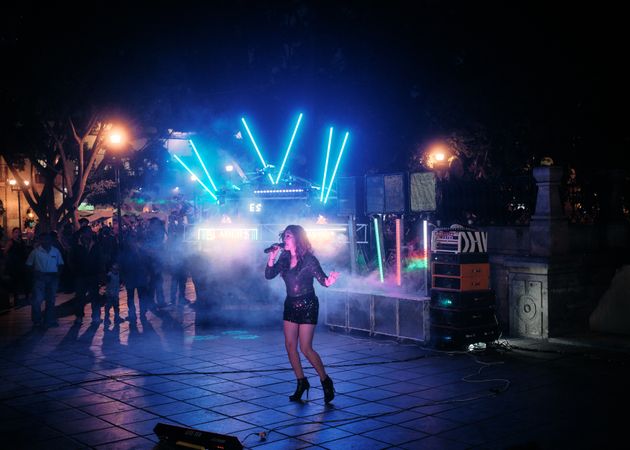 Woman singing at discotheque with lights