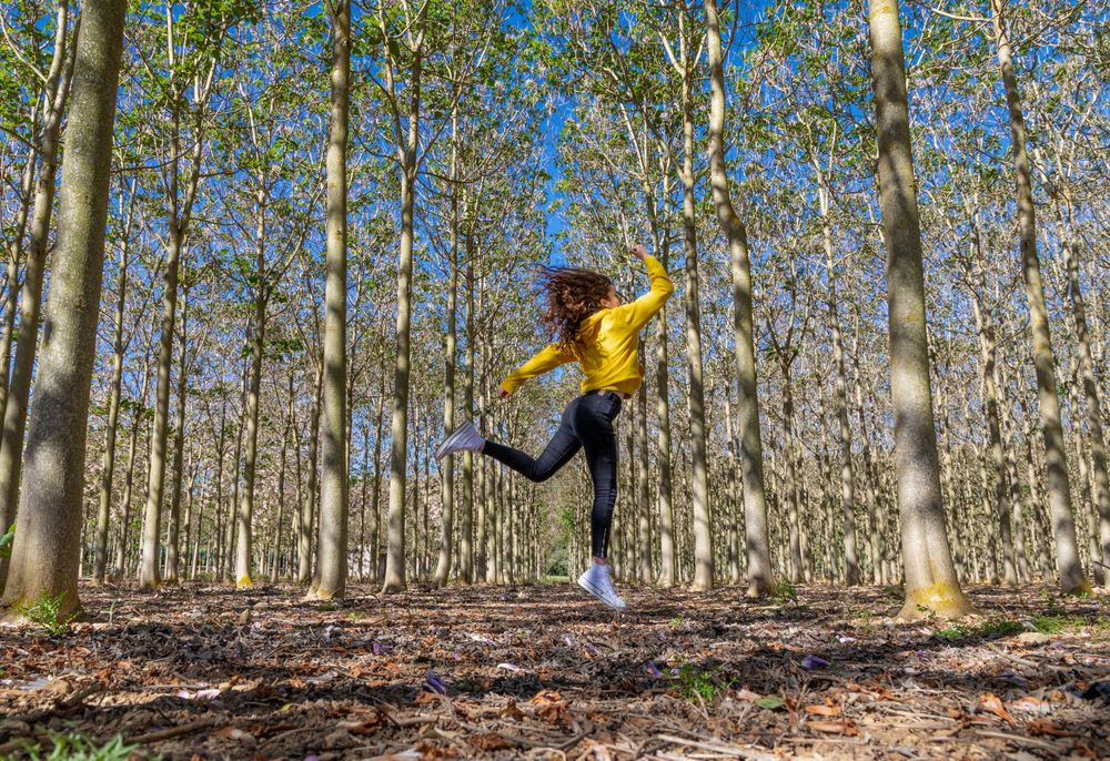 Young sportive female jumping in forest